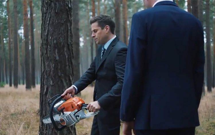 Banker im Wald mit Motorsäge