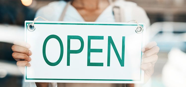 Schild in Schaufenster mit Aufschrift Open