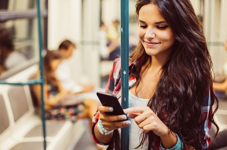 Mädchen in der Strassenbahn mit Smartphone