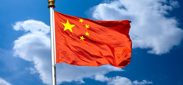 Die Flagge von China im Wind gegen blauen Himmel