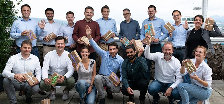 Das Team des FinTechs Loanboox, alle Mitglieder mit einem Geschenkpaket in der Hand.