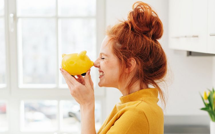 Junge Frau mit Sparschwein in der Hand