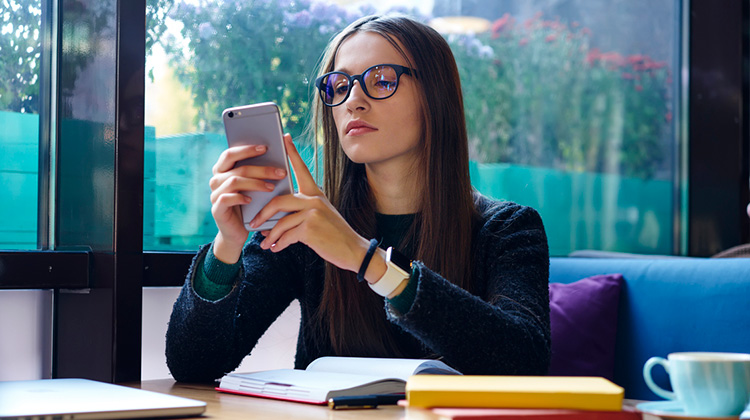 Junge Frau konzentriert am Smartphone