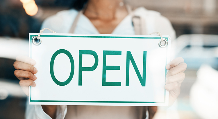 Schild in Schaufenster mit Aufschrift Open