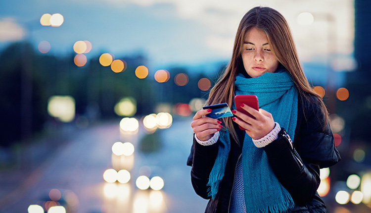 Junge Frau macht eine Zahlung am Smartphone