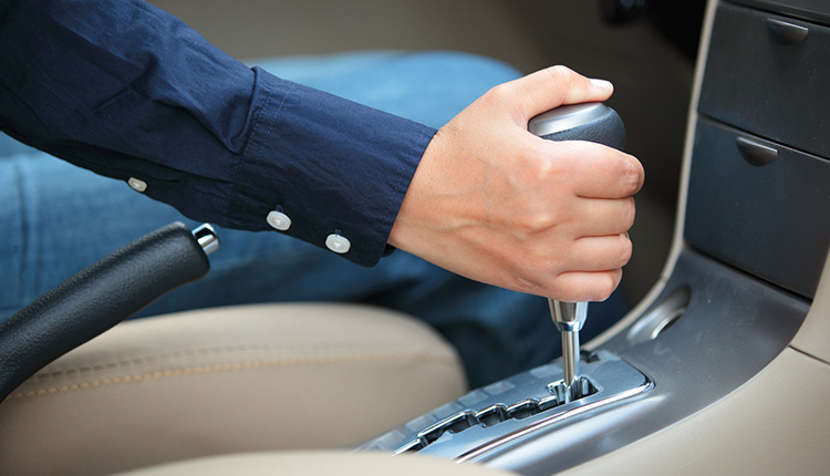 Hand an einer Gangschaltung im Auto